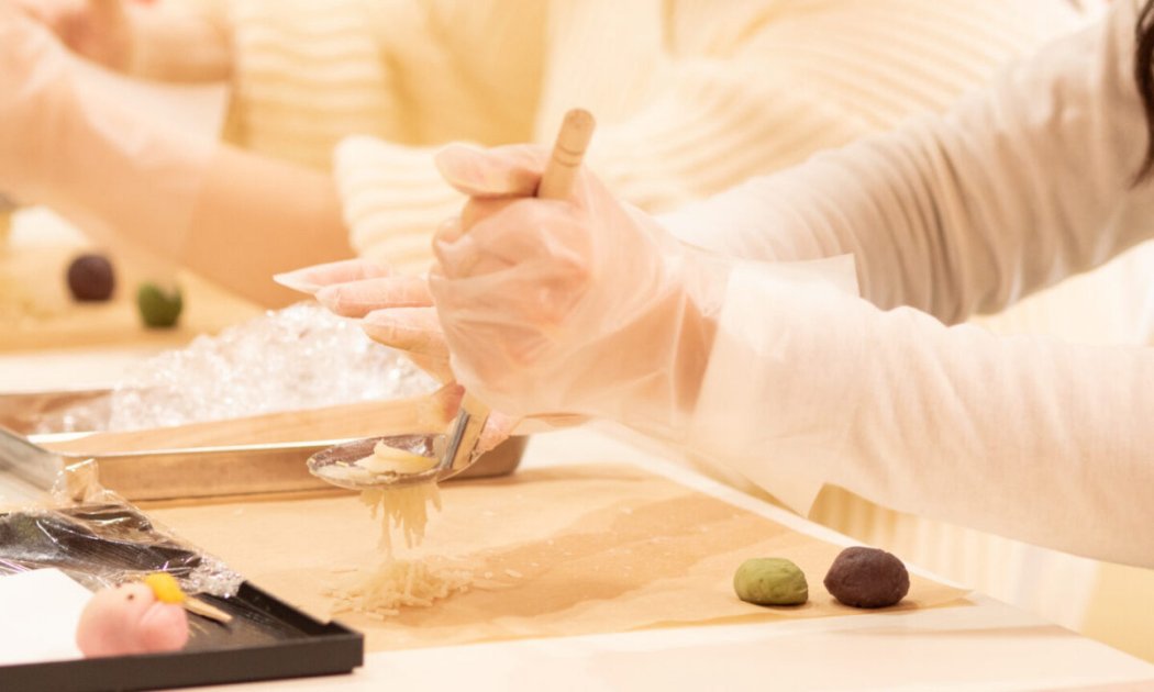 Hands shaping nerikiri wagashi at the workshop