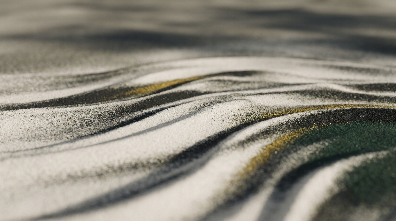Primerísimo plano de arena fina o de una tela texturada, rastrillada en crestas paralelas onduladas en gris, blanco y negro, con una fina vena de oro metálico que recorre los pliegues.